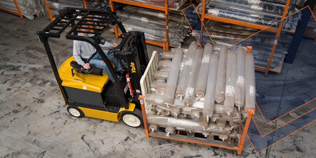Worker using an electric forklift in a warehouse