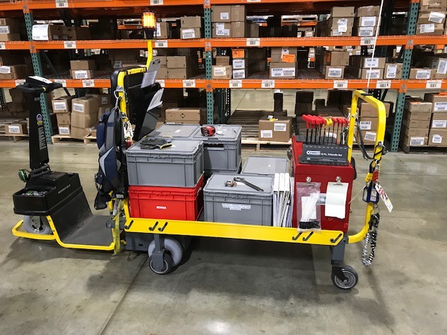 Industrial cart loaded with various boxes and warehouse inventory.